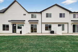 Rear view of property featuring a yard and a patio