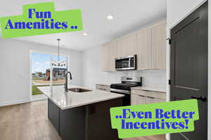 Kitchen with appliances with stainless steel finishes, backsplash, recessed lighting, an island with sink, and hanging light fixtures