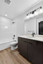 Full bath featuring vanity, shower / bathtub combination, and light wood-type flooring