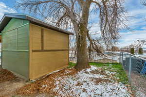 Snow covered structure featuring a storage shed