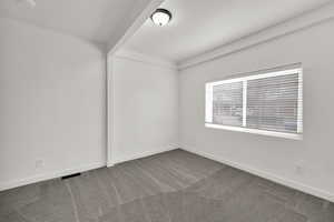 Spare room featuring carpet and baseboards