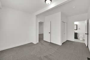 Unfurnished bedroom with carpet floors, a closet, and connected bathroom