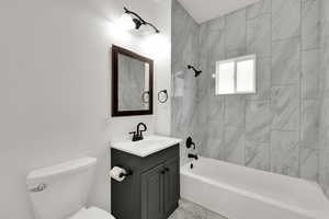 Full bathroom featuring shower / bath combination, vanity, and a textured wall