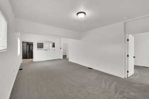 Empty room featuring light carpet and baseboards