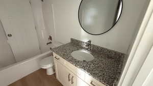 Full bathroom featuring vanity, dark wood-style floors, and shower / bath combination