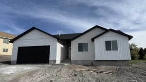 View of front facade featuring a garage and dirt driveway