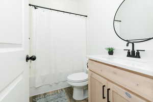 Bathroom featuring vanity, wood finished floors, and shower / bathtub combination with curtain