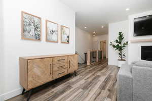 Living area with light wood-type flooring, recessed lighting, and a fireplace