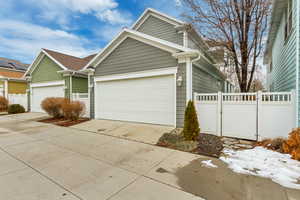 View of property exterior featuring concrete driveway and a gate
