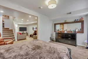 Downstairs Suite Bedroom with light carpet and recessed lighting