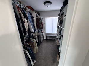 Walk in closet featuring dark carpet