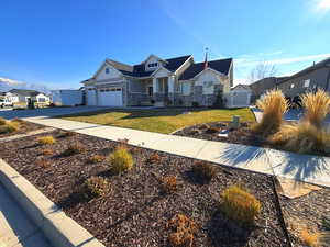 Craftsman house featuring concrete driveway, stone siding, board and batten siding, a residential view, and covered porch