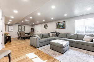 Living room with a textured ceiling, recessed lighting, and light wood finished floors