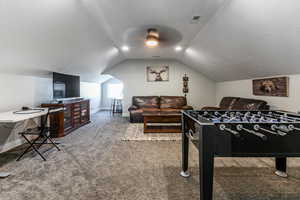 Recreation room with light carpet and vaulted ceiling