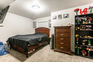 Carpeted bedroom featuring a textured ceiling