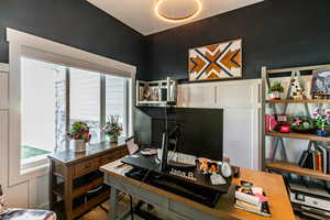 Office featuring healthy amount of natural light, a decorative wall, and wood finished floors