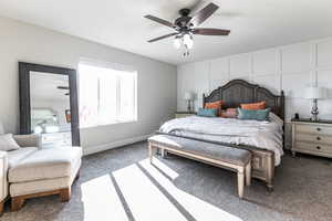 Bedroom with carpet floors, a decorative wall, and a ceiling fan