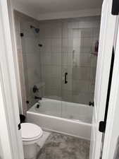 Full bath with enclosed tub / shower combo and toilet