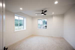 Spare room with plenty of natural light, light carpet, recessed lighting, and a ceiling fan