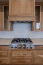 Kitchen featuring premium range hood, stainless steel gas cooktop, and light countertops