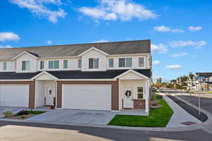 Traditional home with brick siding, driveway, a shingled roof, and an attached garage
