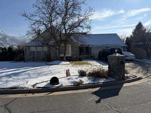 View of front facade featuring driveway, a garage, and stone siding