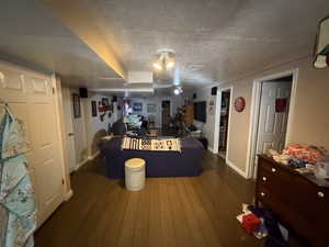 Living room featuring a textured ceiling and dark wood-type flooring