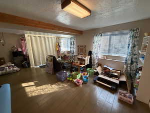 Miscellaneous room with a textured ceiling and dark wood-style flooring