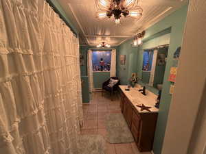 Bathroom featuring a shower with curtain, vanity, light tile patterned floors, and baseboard heating