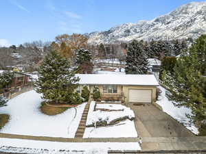 View of front of home featuring a garage, concrete driveway, and a mountain view