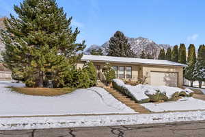 View of front of property with a garage, brick siding, stairs, and a mountain view