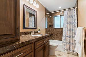 Bathroom featuring vanity, shower / tub combo, and light tile patterned flooring