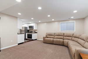 Living area featuring recessed lighting and dark carpet
