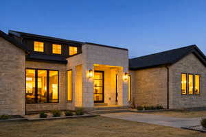 View of front of property featuring stone siding and a front yard