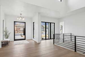 Foyer with light wood-style flooring and a chandelier