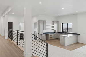 Kitchen featuring a peninsula, open shelves, dark countertops, light wood-style flooring, and recessed lighting