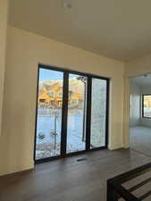 Doorway featuring wood finished floors, plenty of natural light, and a residential view