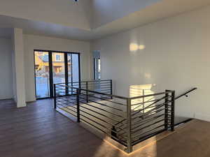 Hallway featuring an upstairs landing and dark wood-style floors