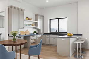 Kitchen featuring a breakfast bar, light wood-type flooring, gray cabinetry, a peninsula, and recessed lighting