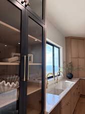 Kitchen with light stone counters, a water view, and wood finished floors