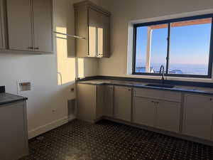 Washroom with hookup for a washing machine, cabinet space, and hookup for an electric dryer