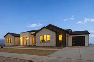 View of front facade featuring a garage and concrete driveway
