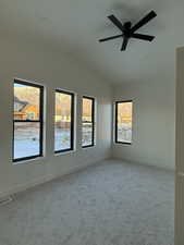 Carpeted spare room with lofted ceiling and ceiling fan