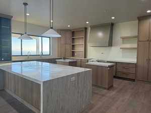 Kitchen featuring open shelves, light stone counters, recessed lighting, hanging light fixtures, and dark wood finished floors