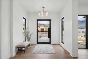 Entrance foyer featuring light wood-type flooring, plenty of natural light, suspended lighting, and a mountain view