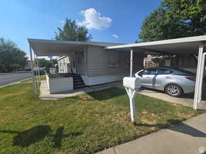 View of front facade with a front yard and an attached carport