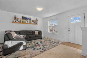 Living room featuring hardwood / wood-style flooring and baseboards