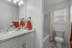 Full bath with vanity, light marble finish floors, and shower / bath combo with shower curtain