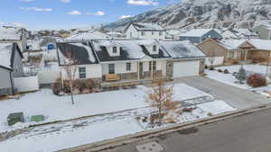 View of front facade featuring stone siding, a porch, concrete driveway, an attached garage, and a residential view
