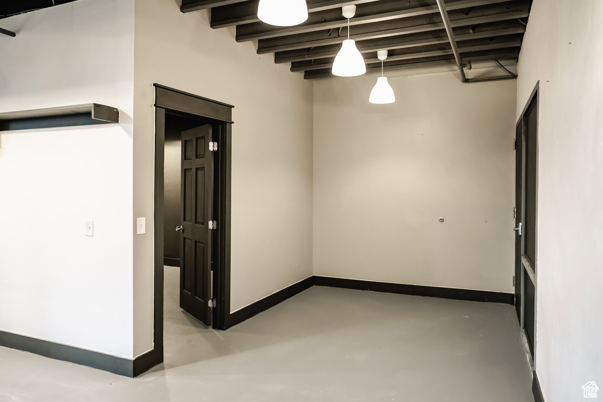 Empty room with concrete floors and baseboards
